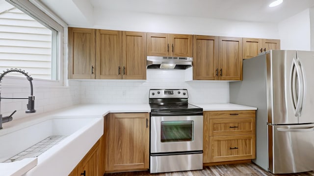 5900 New Hope Ct, Hermitage, TN 37076 - kitchen featuring under cabinet range hood, stainless steel appliances, a sink, backsplash, and light countertops