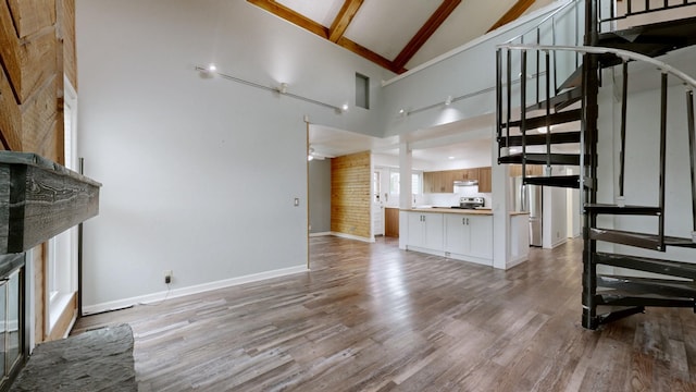 5900 New Hope Ct, Hermitage, TN 37076 - unfurnished living room featuring high vaulted ceiling, stairway, beamed ceiling, baseboards, and light wood finished floors