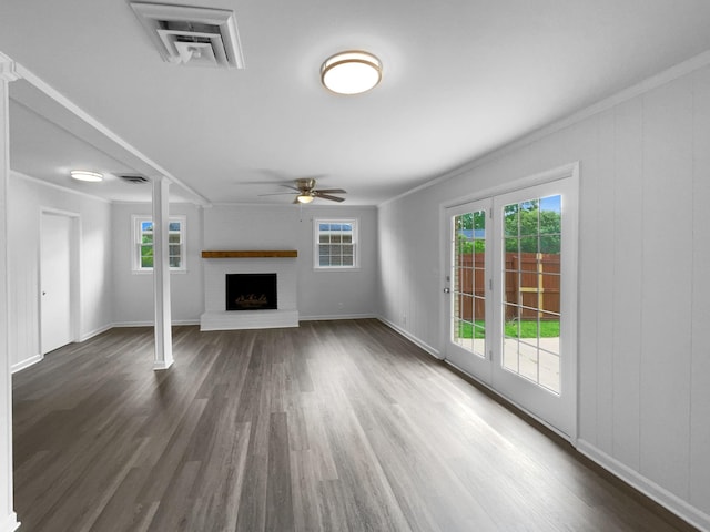 unfurnished living room featuring a ceiling fan, a brick fireplace, healthy amount of natural light, and ornamental molding