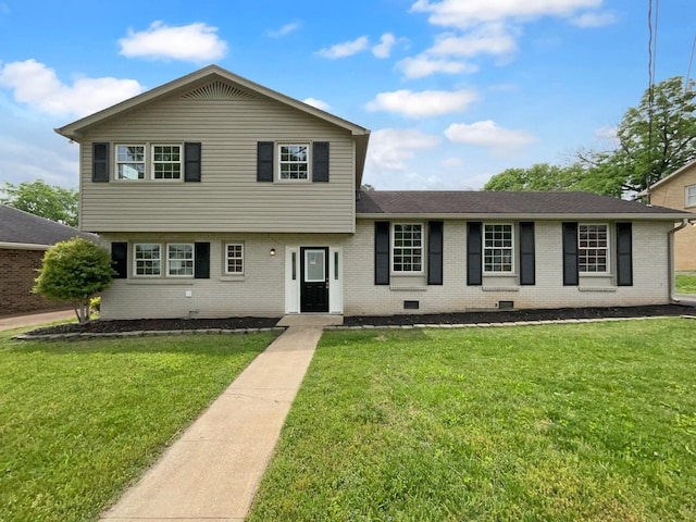 split level home with brick siding and a front yard