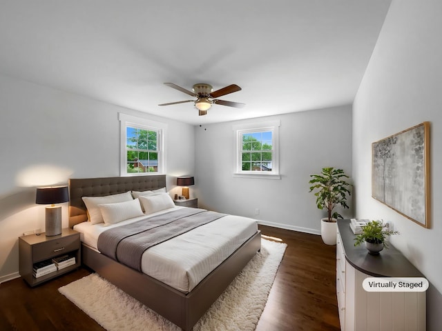 bedroom featuring multiple windows, baseboards, dark wood-style floors, and a ceiling fan