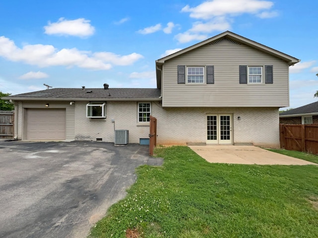 rear view of house featuring a garage, brick siding, central AC, a patio, and driveway