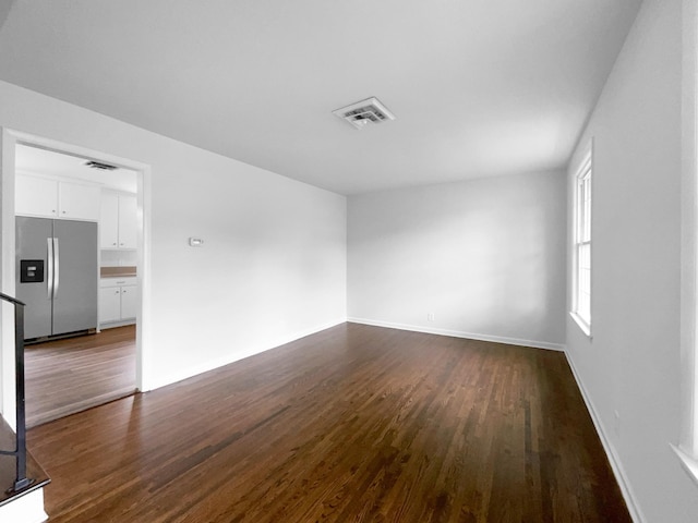 spare room with dark wood finished floors and baseboards