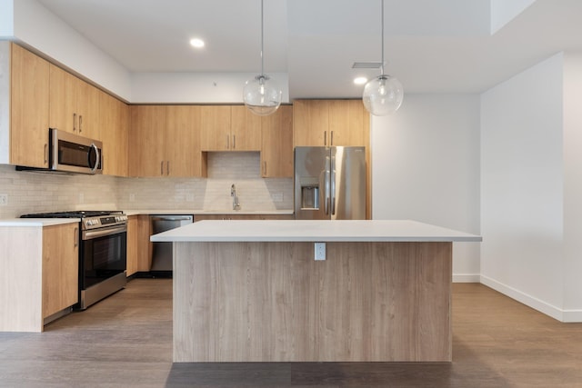 kitchen featuring stainless steel appliances, light countertops, tasteful backsplash, a center island, and recessed lighting