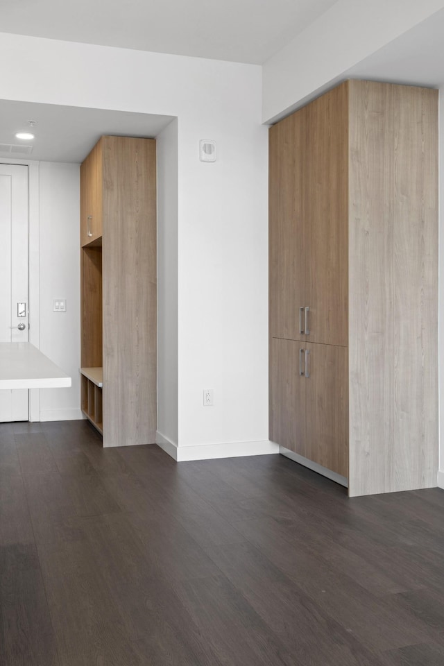 unfurnished living room with dark wood finished floors and baseboards