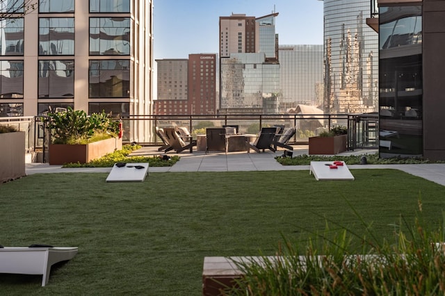 view of grassy yard with a city view and a patio area