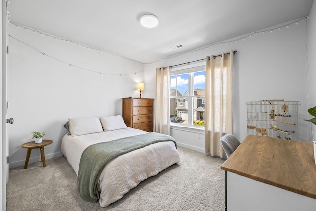 bedroom with light colored carpet and baseboards