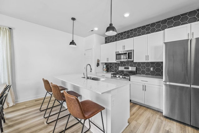 kitchen with stainless steel appliances, a sink, white cabinetry, and recessed lighting