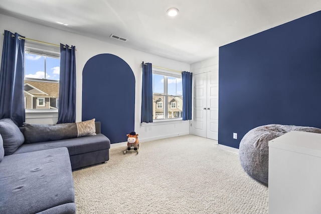 carpeted living room with healthy amount of natural light and baseboards