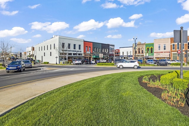 view of asphalt street featuring street lights and curbs