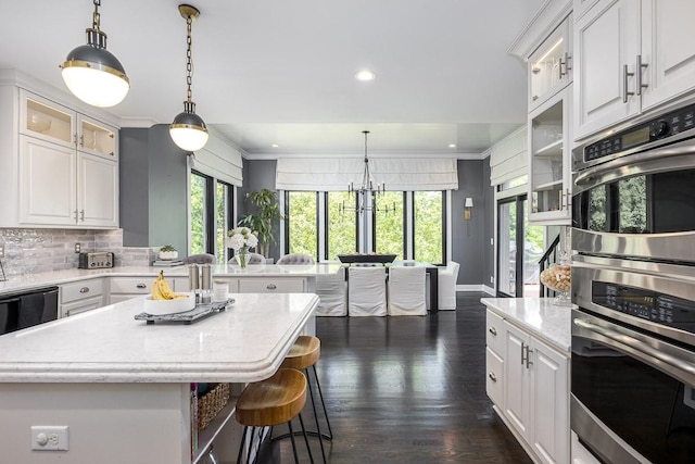 716 Split Rail Dr, Brentwood, TN 37027 - kitchen with white cabinetry, glass insert cabinets, a kitchen bar, recessed lighting, and decorative light fixtures