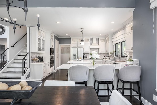 716 Split Rail Dr, Brentwood, TN 37027 - kitchen with stainless steel refrigerator with ice dispenser, wall chimney exhaust hood, light countertops, a breakfast bar area, and ornamental molding