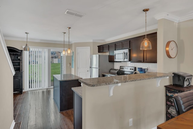 127 Cobblestone Place Dr, Goodlettsville, TN 37072 - kitchen with appliances with stainless steel finishes, dark brown cabinets, a center island, dark wood-type flooring, and a kitchen breakfast bar