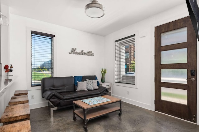 living room with finished concrete flooring and baseboards