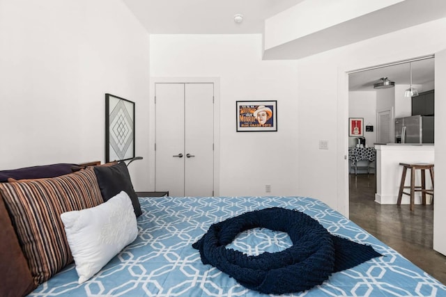 bedroom featuring stainless steel fridge with ice dispenser and a closet