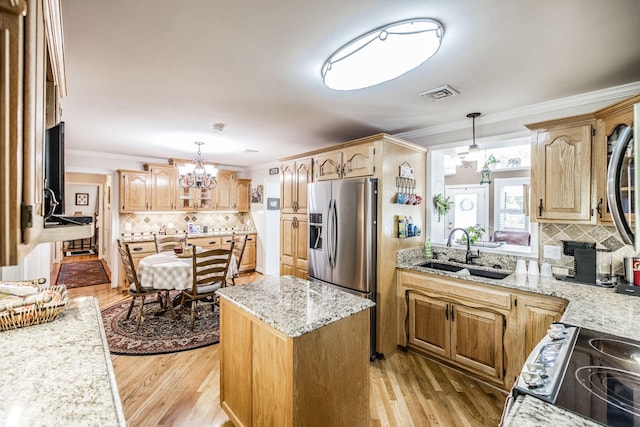 kitchen featuring a sink, stainless steel refrigerator with ice dispenser, ornamental molding, electric range, and a chandelier