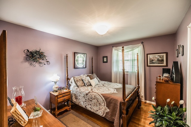 bedroom featuring wood finished floors and baseboards