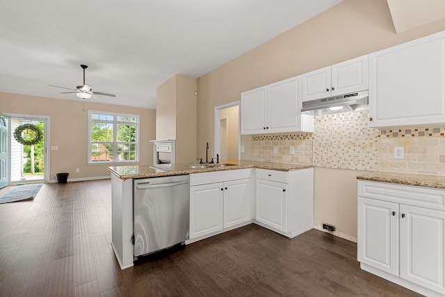 kitchen with dishwasher, under cabinet range hood, a peninsula, a sink, and dark wood finished floors