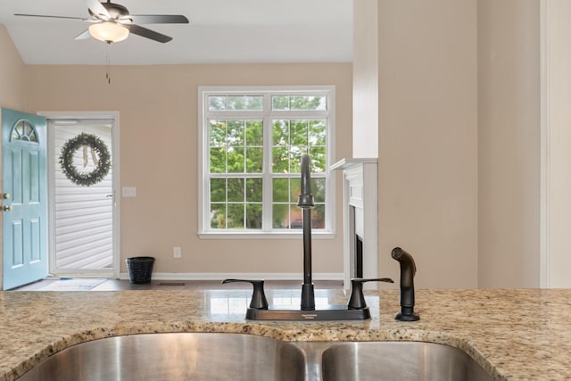 foyer entrance with ceiling fan and a fireplace