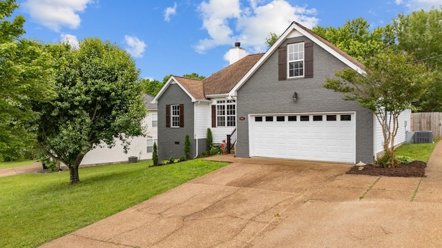 traditional home with a chimney, a garage, concrete driveway, brick siding, and central air condition unit