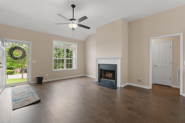 unfurnished living room with ceiling fan, a fireplace with flush hearth, vaulted ceiling, wood finished floors, and baseboards