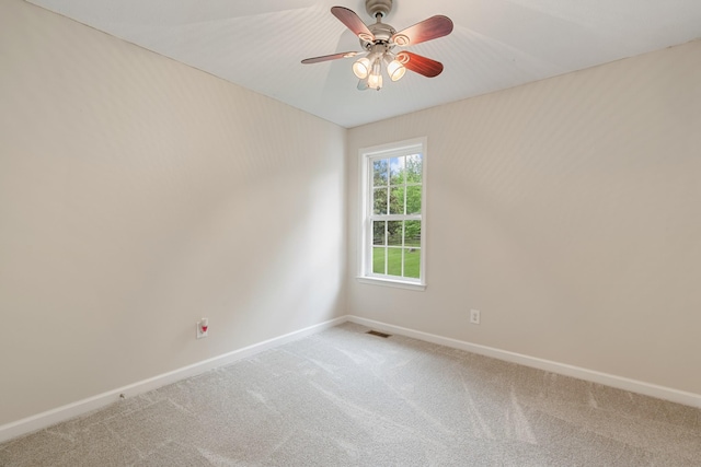 empty room featuring light colored carpet, baseboards, and ceiling fan