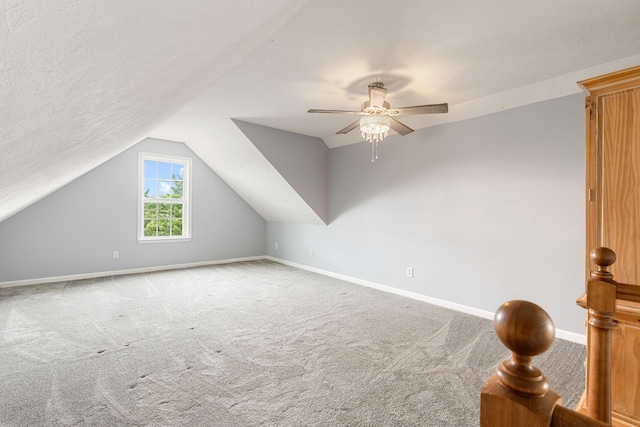 additional living space featuring carpet, baseboards, vaulted ceiling, and a ceiling fan