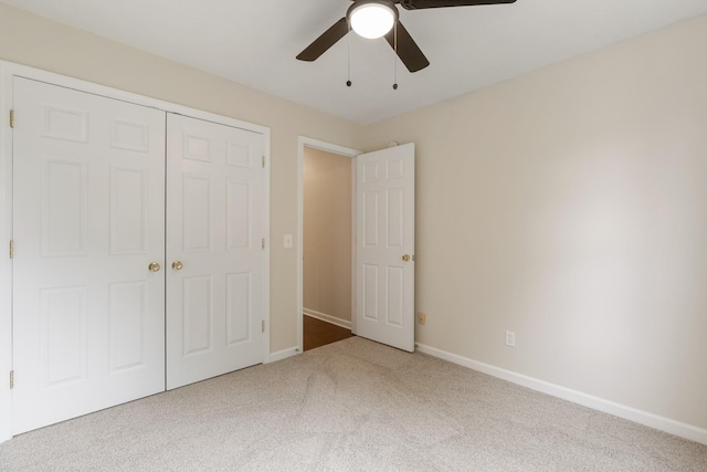 unfurnished bedroom with carpet flooring, a closet, baseboards, and a ceiling fan