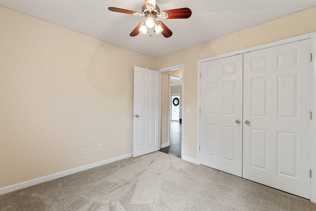 unfurnished bedroom featuring carpet flooring, baseboards, a closet, and ceiling fan