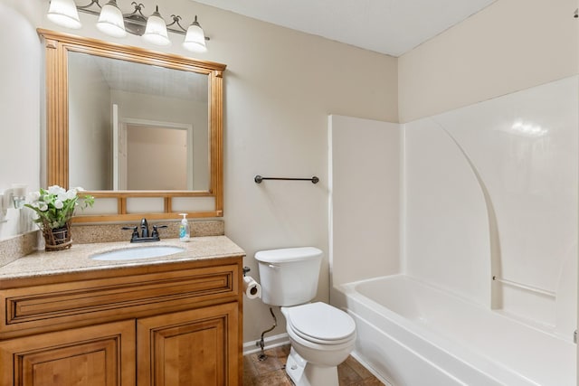 full bathroom with toilet, vanity, and baseboards