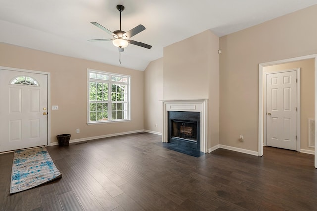 unfurnished living room featuring a ceiling fan, dark wood-type flooring, lofted ceiling, baseboards, and a fireplace with flush hearth