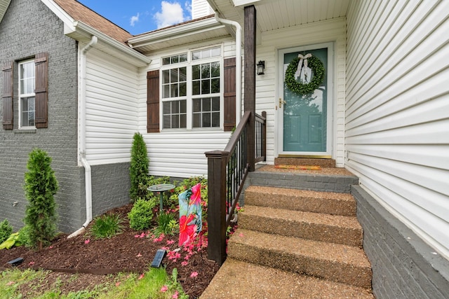 entrance to property featuring brick siding