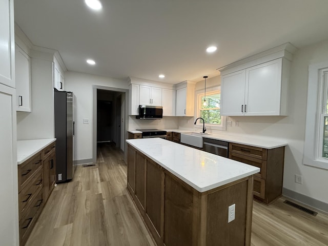 305 Twelve Oaks Rd, Tullahoma, TN 37388 - kitchen featuring stainless steel appliances, light wood-style floors, a sink, white cabinetry, and baseboards