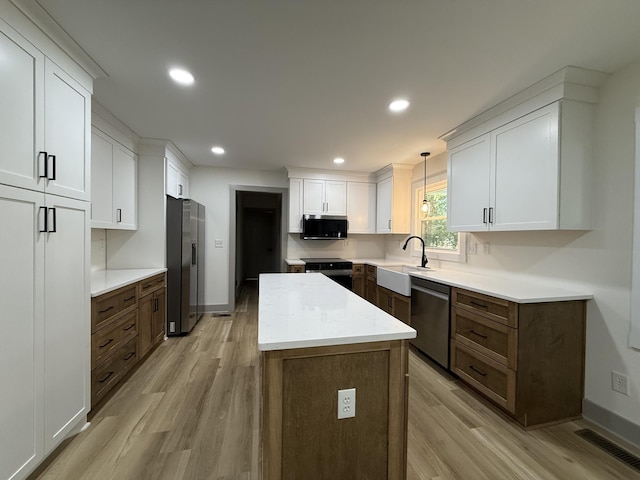 305 Twelve Oaks Rd, Tullahoma, TN 37388 - kitchen featuring appliances with stainless steel finishes, a sink, light wood finished floors, a kitchen island, and recessed lighting