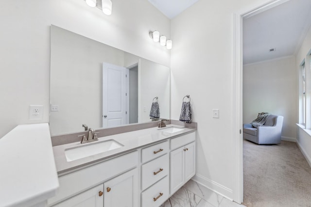 bathroom featuring baseboards, double vanity, marble finish floors, and crown molding