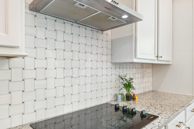 kitchen featuring ventilation hood, decorative backsplash, white cabinets, and light stone countertops