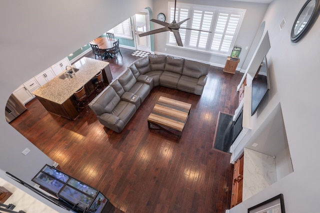 living area with hardwood / wood-style flooring, baseboards, and a ceiling fan