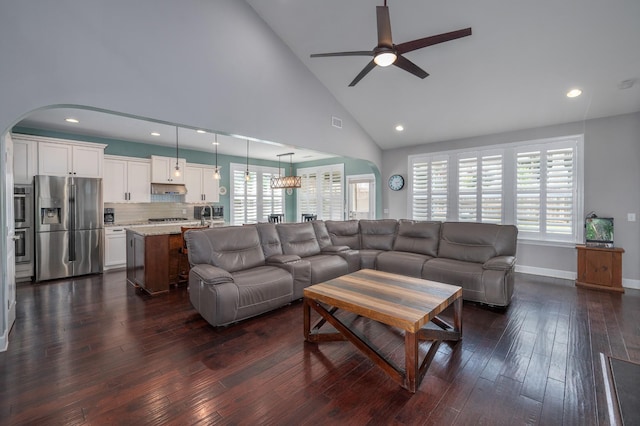 living room with a ceiling fan, arched walkways, dark wood finished floors, recessed lighting, and high vaulted ceiling
