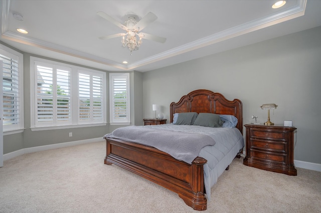 carpeted bedroom with a tray ceiling, crown molding, baseboards, recessed lighting, and a ceiling fan