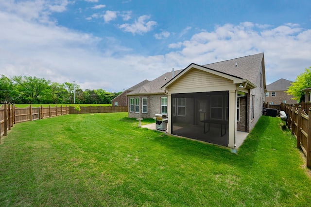 rear view of property featuring a patio, brick siding, a sunroom, and roof with shingles
