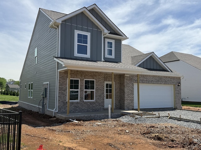 view of front of house featuring a porch, board and batten siding, a garage, driveway, and a shingled roof