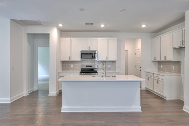 kitchen featuring appliances with stainless steel finishes, a sink, backsplash, light countertops, and recessed lighting