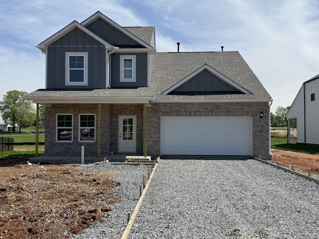 view of front of property featuring driveway, board and batten siding, a shingled roof, a garage, and brick siding