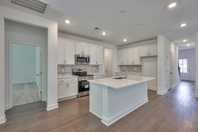kitchen with appliances with stainless steel finishes, a sink, white cabinetry, and recessed lighting