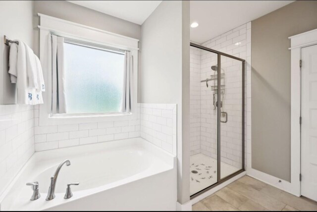 bathroom featuring a shower stall, a garden tub, recessed lighting, and baseboards