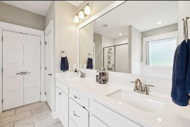 full bathroom with a stall shower, double vanity, tile patterned floors, and recessed lighting