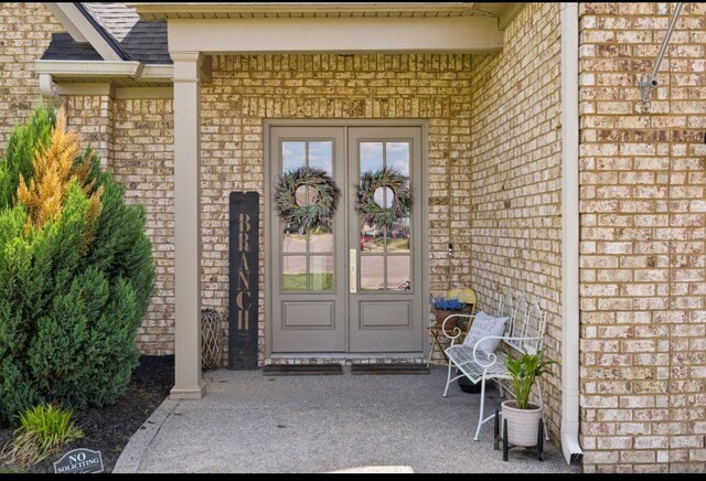 doorway to property featuring brick siding and french doors