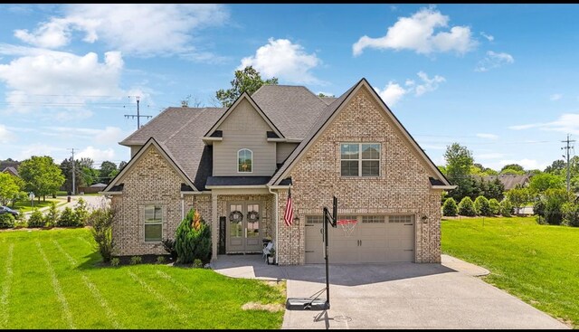 view of front of house featuring a front yard, driveway, french doors, an attached garage, and brick siding