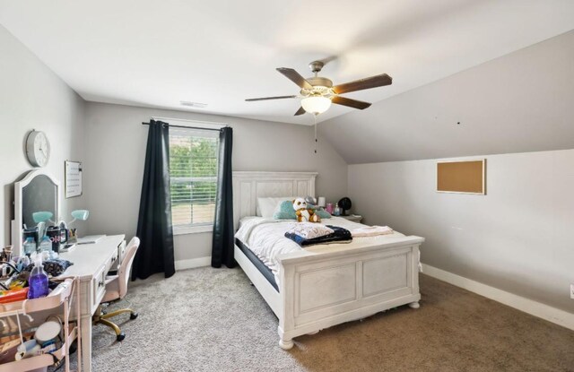 bedroom featuring light carpet, baseboards, vaulted ceiling, and a ceiling fan