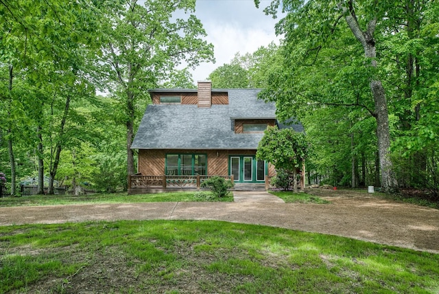 rustic home featuring a chimney, french doors, a front yard, and roof with shingles